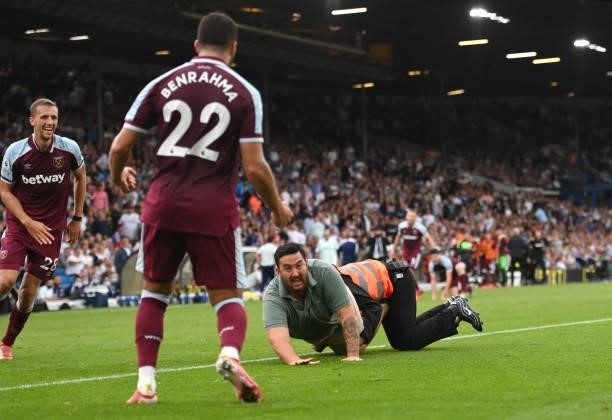 Pitch invader is seen celebrating their side's second goal with Tomas Soucek and Said Benrahma scored by Michail Antonio of West Ham United despite...