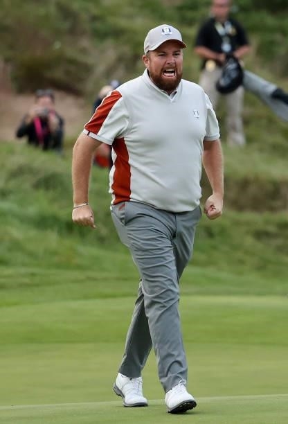 Shane Lowry of Ireland and team Europe celebrates his putt on the 18th green to win his match with Tyrrell Hatton of England and team Europe 1up over...