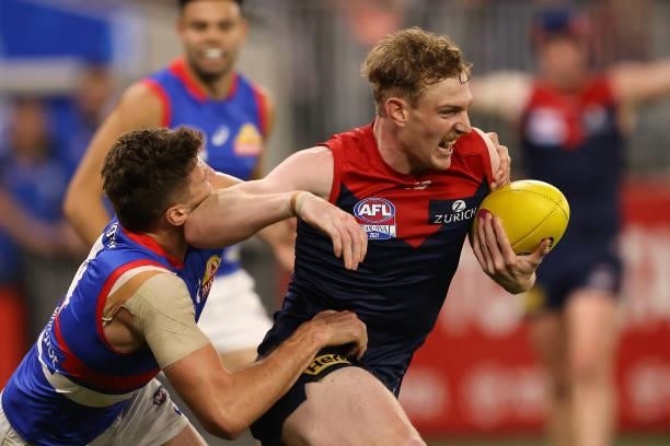 Harrison Petty of the Demons gets tackled by Marcus Bontempelli of the Bulldogs during the 2021 AFL Grand Final match between the Melbourne Demons...