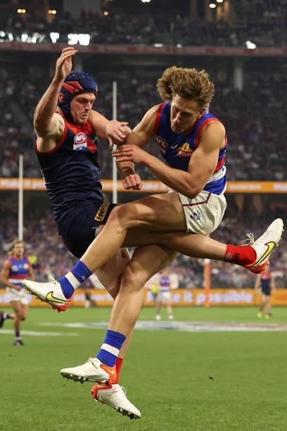 Angus Brayshaw of the Demons gets bumped by Aaron Naughton of the Bulldogs during the 2021 AFL Grand Final match between the Melbourne Demons and the...
