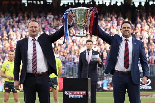 Premiership presenters Chris Grant and Garry Lyon hold the cup aloft during the 2021 AFL Grand Final match between the Melbourne Demons and the...