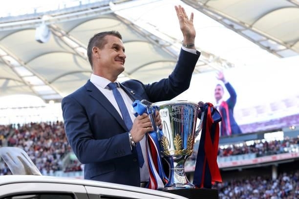 Glen Jakovich waves to the crowd while delivering the premiership cup during the 2021 AFL Grand Final match between the Melbourne Demons and the...