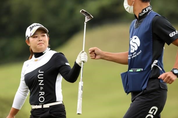 Saki Asai of Japan fist bumps with her caddie after the birdie on the 8th green during the final round of the Miyagi TV Cup Dunlop Ladies Open at...
