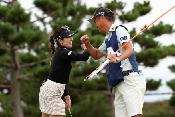 Yuna Nishimura of Japan fist bumps with her caddie after winning the tournament on the 18th green during the final round of the Miyagi TV Cup Dunlop...