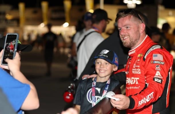 Justin Allgaier, driver of the BRANDT Chevrolet, poses for photos with a young fan after the NASCAR Xfinity Series Alsco Uniforms 302 at Las Vegas...