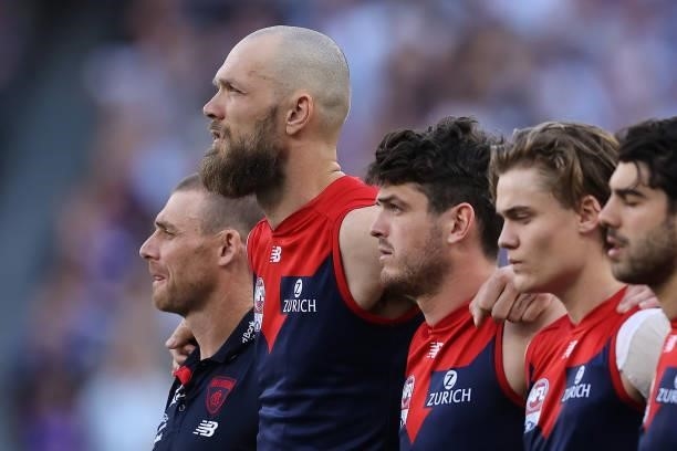 Simon Goodwin, Max Gawn and Angus Brayshaw of the Demons look on as the teams line up during the 2021 AFL Grand Final match between the Melbourne...