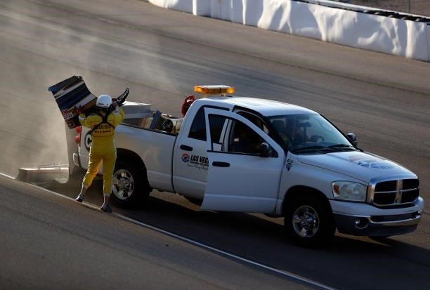 Member of the track crew cleans the driving surface of debris after an incident during the NASCAR Xfinity Series Alsco Uniforms 302 at Las Vegas...