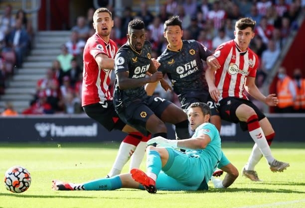 Alex McCarthy of Southampton makes a save from Nelson Semedo and Hee-chan Hwang of Wolverhampton Wanderers during the Premier League match between...