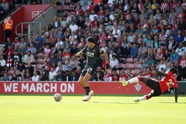 Raul Jimenez of Wolverhampton Wanderers crosses over Mohammed Salisu of Southampton on his way to scoring his team's first goal during the Premier...