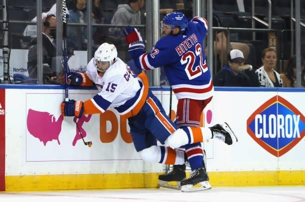 Anthony Bitetto of the New York Rangers checks Cal Clutterbuck of the New York Islanders during the second period in a preseason game at Madison...