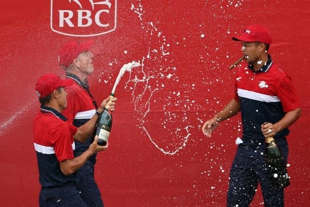 Xander Schauffele , Collin Morikawa, and vice-captain Jim Furyk of team United States celebrate with champagne after defeating team Europe during...