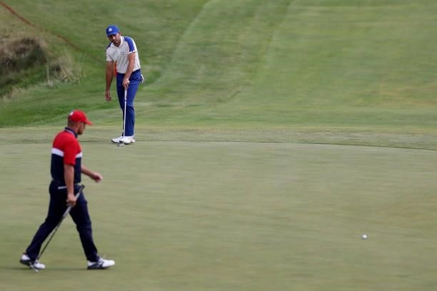 Sergio Garcia of Spain and team Europe reacts to his putt on the on the ninth green as Bryson DeChambeau of team United States looks on during Sunday...