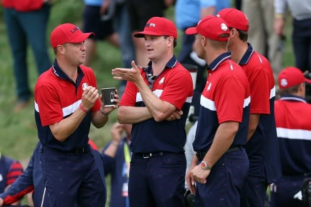 Justin Thomas of team United States talks with vice-captain Zach Johnson and Daniel Berger of team United States during Sunday Singles Matches of the...