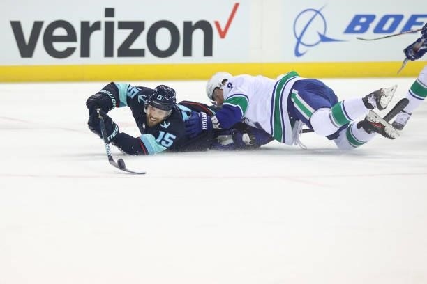 Riley Sheahan of the Seattle Kraken and Tucker Poolman of the Vancouver Canucks collide to gain possession of the puck in the first period during a...
