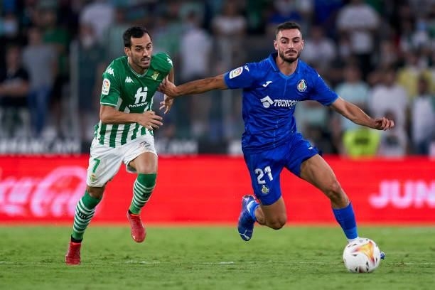Juanmi Jimenez of Real Betis competes for the ball with Juan Antonio Iglesias of Getafe CF during the LaLiga Santander match between Real Betis and...