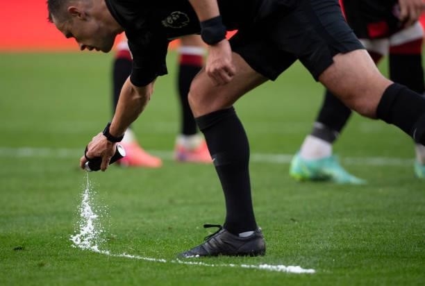 Referee Stuart Attwell uses his white spray before a free-kick during the Premier League match between Brentford and Liverpool at Brentford Community...