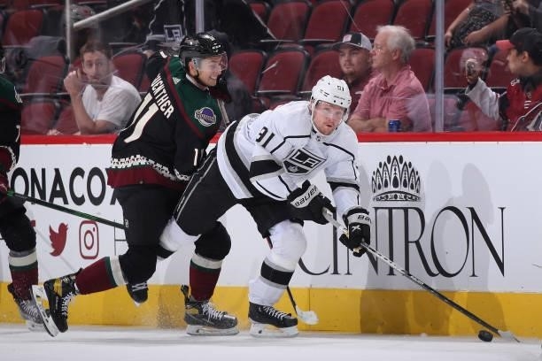 Carl Grundstrom of the Los Angeles Kings controls the puck ahead of Dylan Guenther of the Arizona Coyotes during the third period of the preseason...