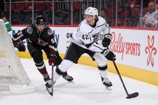 Martin Chromiak of the Los Angeles Kings skates with the puck ahead of Cameron Crotty of the Arizona Coyotes during the third period of the preseason...