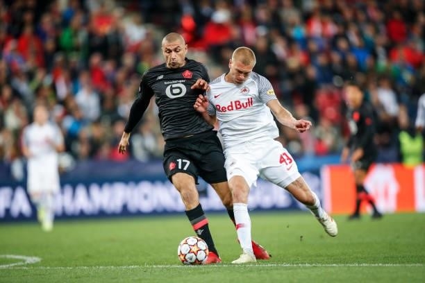 Rasmus Kristensen of FC Red Bull Salzburg challenges Burak Yilmaz of Lille OSC during the UEFA Champions League group G match between FC Salzburg and...
