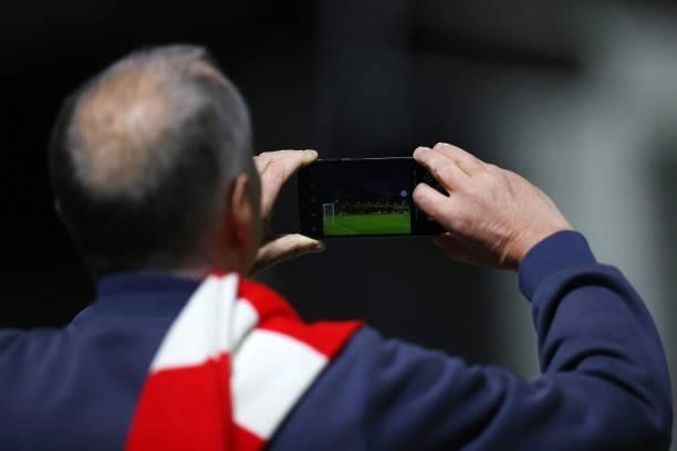 Fan takes a photo during the Vitality Women's FA Cup Quarter Final match between Arsenal and Tottenham Hotspur at Meadow Park on September 29, 2021...