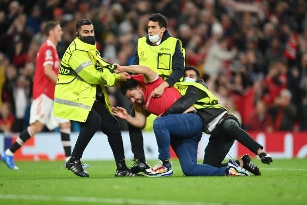 Manchester United fan is escorted from the pitch by stewards during the UEFA Champions League group F match between Manchester United and Villarreal...