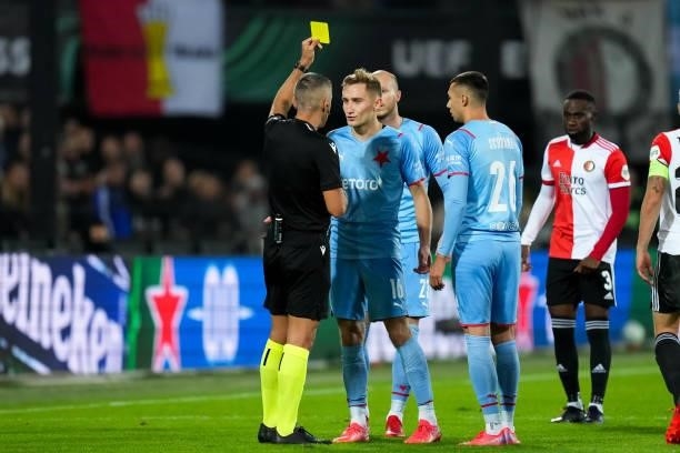 Referee Radu Petrescu shows a yellow card to Jan Kuchta of Slavia Prague during the UEFA Conference League Group Stage match between Feyenoord and...