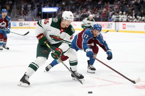 Brandon Duhaime of the Minnesota Wild advances the puck against Tyson Jost of the Colorado Avalanche in the first period at Ball Arena on September...