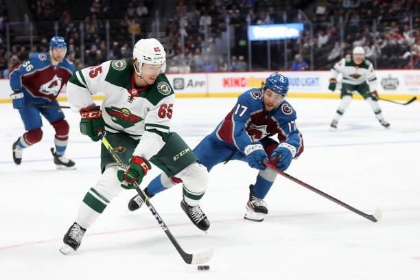 Brandon Duhaime of the Minnesota Wild advances the puck against Tyson Jost of the Colorado Avalanche in the first period at Ball Arena on September...