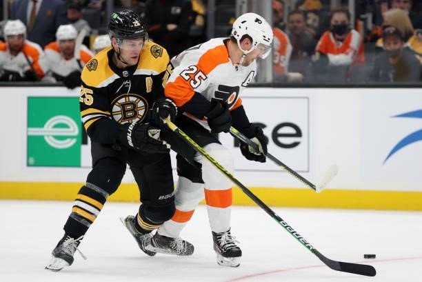 Brandon Carlo of the Boston Bruins and James van Riemsdyk of the Philadelphia Flyers battle for control of the puck during the second period of the...