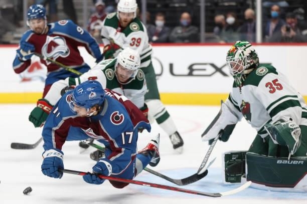 Tyson Jost of the Colorado Avalanche is tripped by Kevin Czuczman of the Minnesota Wild in the second period at Ball Arena on September 30, 2021 in...