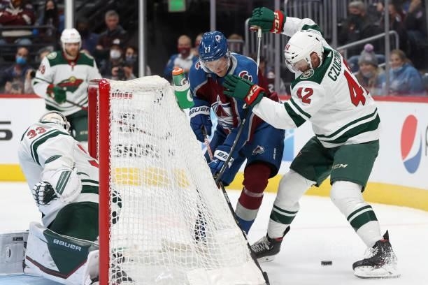 Oskar Olausson and of the Colorado Avalanche pass the puck behind the net against Kevin Czuczman of the Minnesota Wild in the second period at Ball...