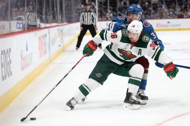 Mats Zuccarello of the Minnesota Wild fights for the puck the puck against J.T. Compher of the Colorado Avalanche in the first period at Ball Arena...