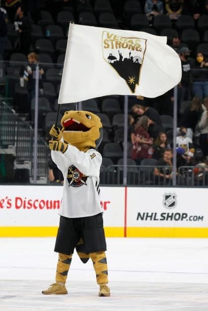The Vegas Golden Knights mascot Chance the Golden Gila Monster waves a "Vegas Strong