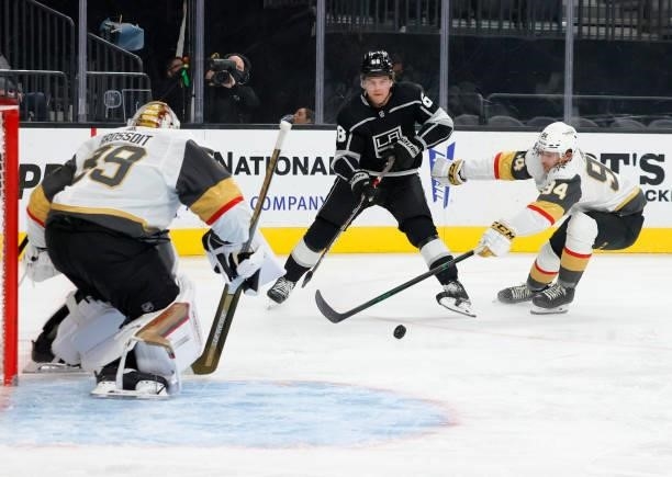 Samuel Fagemo of the Los Angeles Kings passes under pressure from Brayden Pachal of the Vegas Golden Knights as Laurent Brossoit of the Golden...