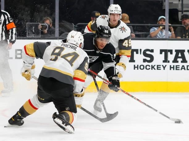 Quinton Byfield of the Los Angeles Kings skates with the puck against Brayden Pachal and Peter DiLiberatore of the Vegas Golden Knights in the third...