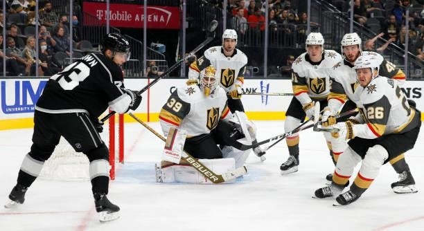 The puck flies by Dustin Brown of the Los Angeles Kings after Laurent Brossoit of the Vegas Golden Knights made a save on a shot by Anze Kopitar of...