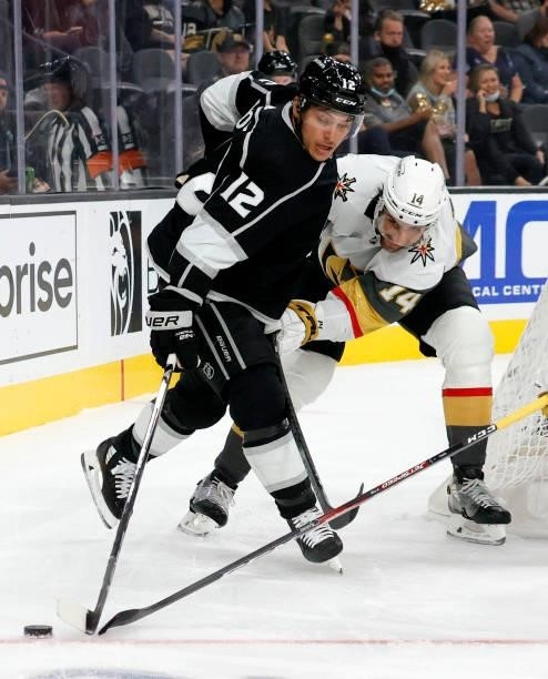 Trevor Moore of the Los Angeles Kings tries to control the puck against Nicolas Hague of the Vegas Golden Knights in the third period of their...
