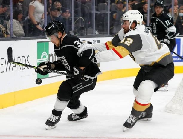 Viktor Arvidsson of the Los Angeles Kings tries to control the puck against Daniil Miormanov of the Vegas Golden Knights in the third period of their...