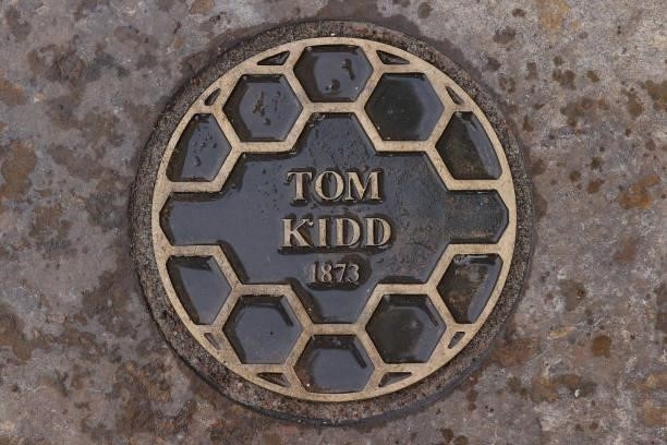 Plaque commemorating The Open Championship win of Tom Kidd in 1873, the first to be held at St Andrews, is seen on the pavement alongside the 18th...