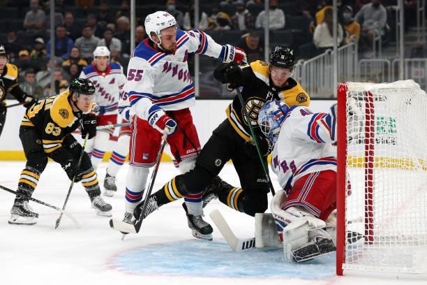 Ryan Lindgren of the New York Rangers shoves Trent Frederic of the Boston Bruins into the goal during the first period of the preseason game at TD...
