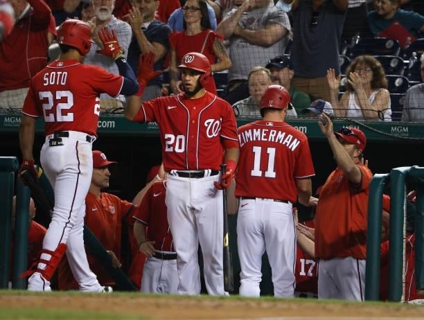 Juan Soto and Ryan Zimmerman are congratulated by teammates after Soto hit a sacrifice fly, sending home Zimmerman, in the eighth inning against the...