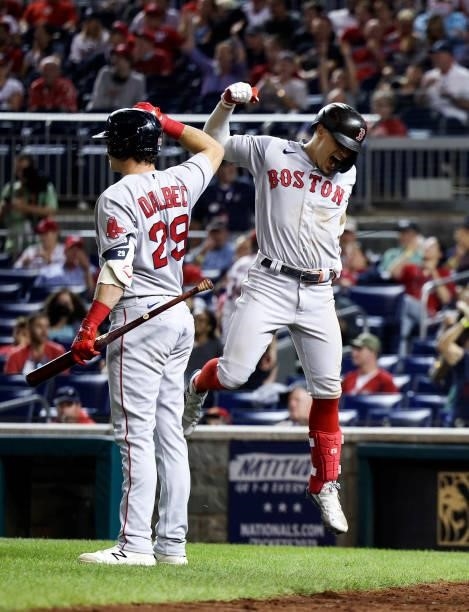 Bobby Dalbec of the Boston Red Sox celebrates with teammate Enrique Hernandez after Hernandez hit a two-run home run in the ninth inning against the...