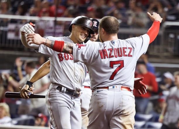Christian Vazquez of the Boston Red Sox celebrates with teammate Enrique Hernandez after Hernandez hit a two-run home run in the ninth inning against...