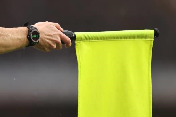 The lineman raises an offside flag as his watch shows a hawk-eye goal decision during the Premier League match between Chelsea and Southampton at...