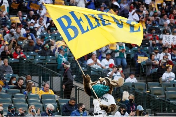 The Mariner Moose waves a flag that reads "believe