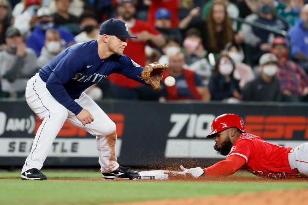Luis Rengifo of the Los Angeles Angels dives safely into third base against Kyle Seager of the Seattle Mariners at T-Mobile Park on October 02, 2021...