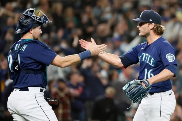 Cal Raleigh and Drew Steckenrider of the Seattle Mariners react after beating the Los Angeles Angels 6-4 at T-Mobile Park on October 02, 2021 in...