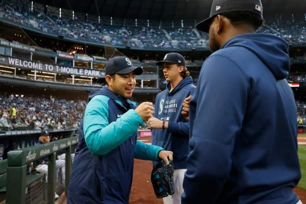 Yusei Kikuchi of the Seattle Mariners fist bumps teammates before the game against the Los Angeles Angels at T-Mobile Park on October 02, 2021 in...