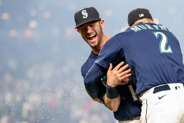 Mitch Haniger and Tom Murphy of the Seattle Mariners react after beating the Los Angeles Angels 6-4 at T-Mobile Park on October 02, 2021 in Seattle,...