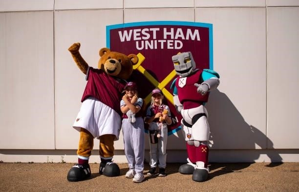 Young fans pose for a picture with West Ham United mascots Hammerhead and Bubbles prior to the Premier League match between West Ham United and...